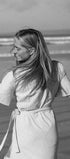Woman standing on a beach with long hair flowing, black and white photo