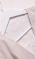 Light pink textured fabric with a white label on a light pink background