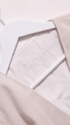 Light pink textured fabric with a white label on a light pink background