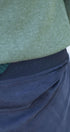 Close-up of a green sweater and blue pants with embroidery