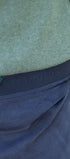 Close-up of a green sweater and blue pants with embroidery