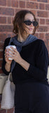 Woman holding a coffee cup against a brick wall