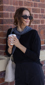 Woman holding a coffee cup against a brick wall