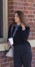 Woman holding a coffee cup against a brick wall