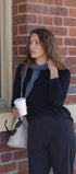 Woman holding a coffee cup against a brick wall