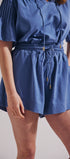 Blue romper worn by a person on a plain background