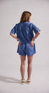 Woman wearing a blue outfit with a plain background