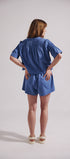 Woman wearing a blue outfit with a plain background