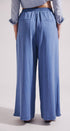 Person wearing blue wide-leg pants and a light blue shirt on a white background