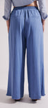 Person wearing blue wide-leg pants and a light blue shirt on a white background