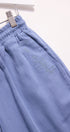 Blue pants with text embroidery on a white background