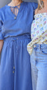 Two women wearing a blue dress and floral top with jeans.