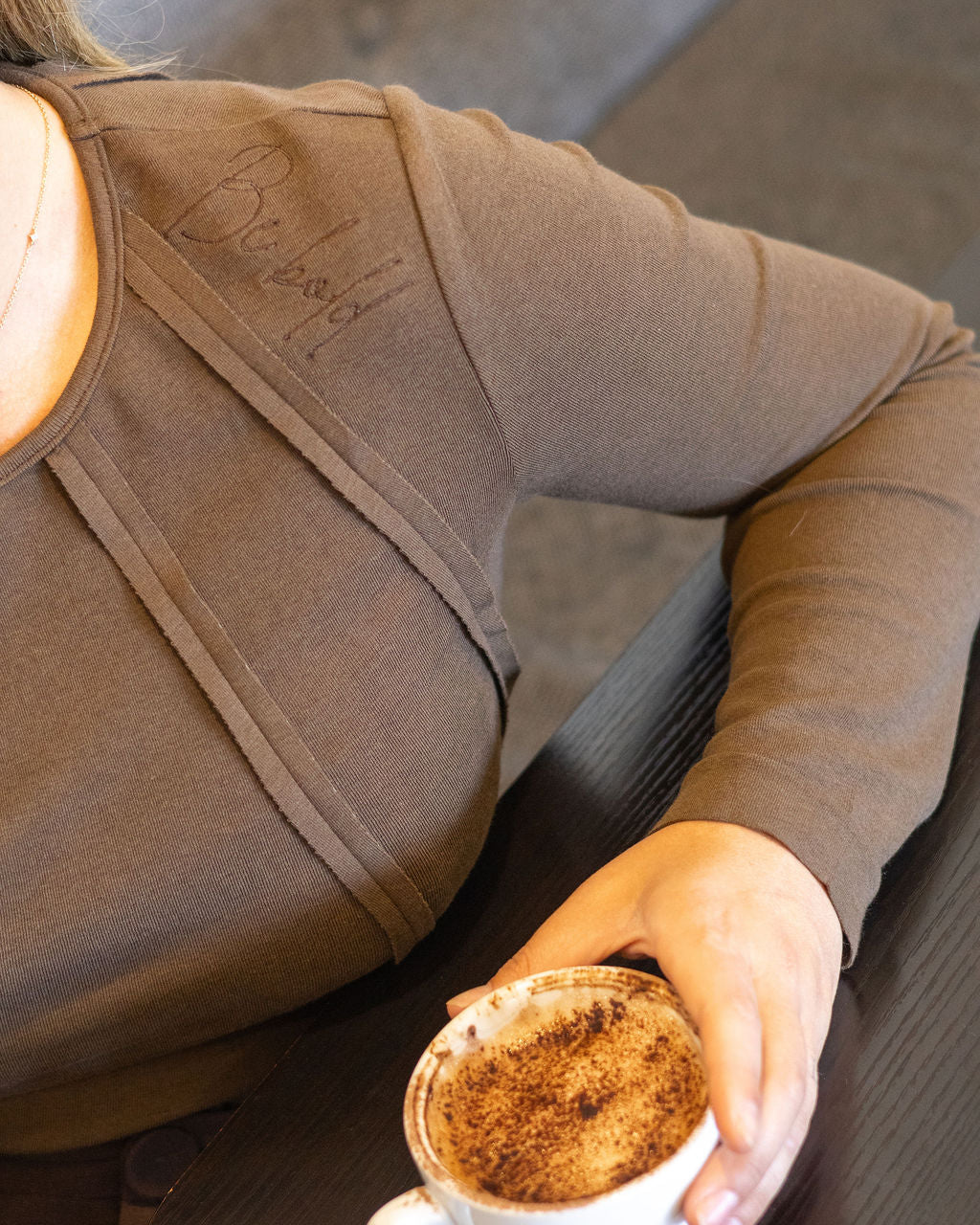 Person holding a cup of coffee in a casual setting
