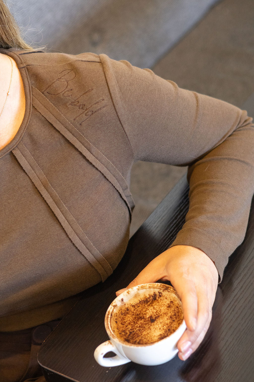 Person holding a cup of coffee in a casual setting