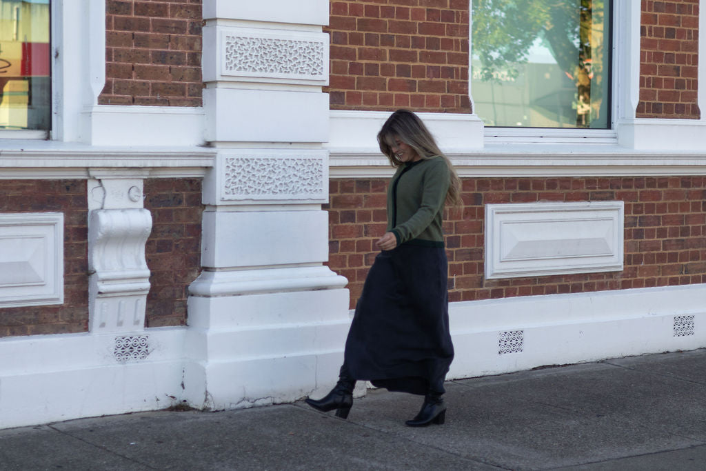 Woman walking on a sidewalk in front of a brick building