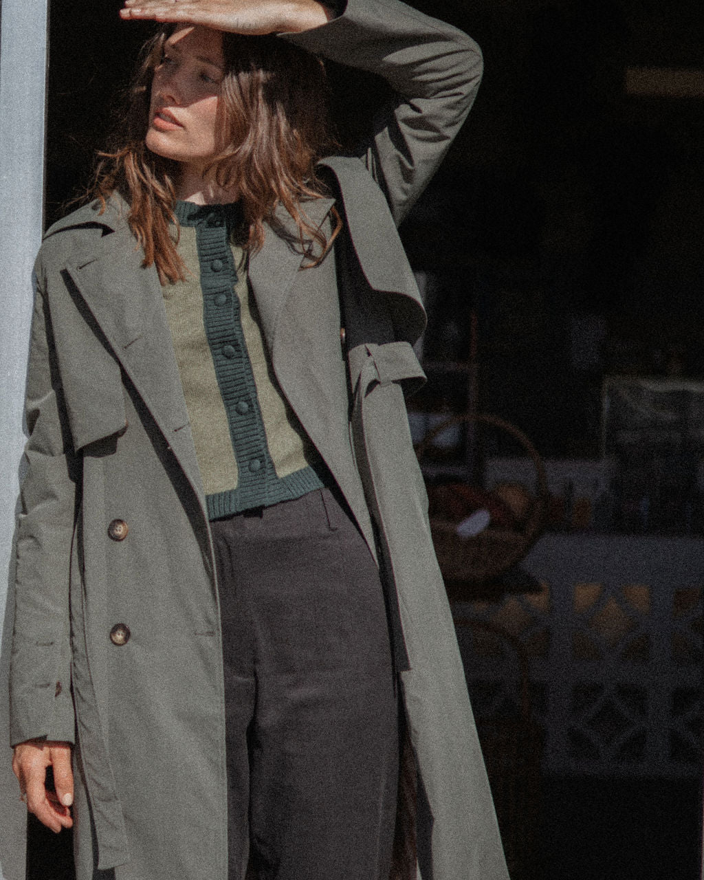 Person wearing a long green coat in an urban setting