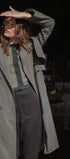 Person wearing a long green coat in an urban setting