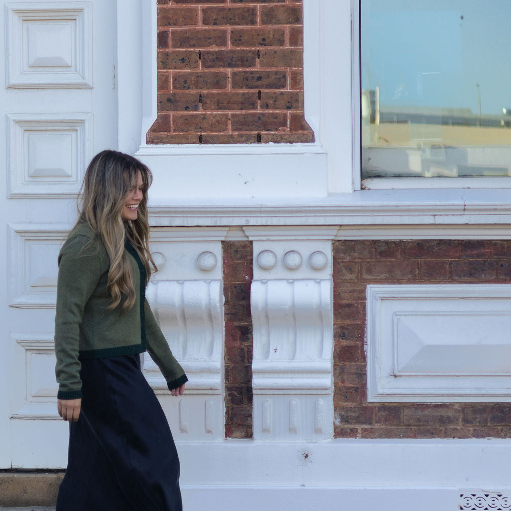 Woman walking in front of a brick building with white decorative elements