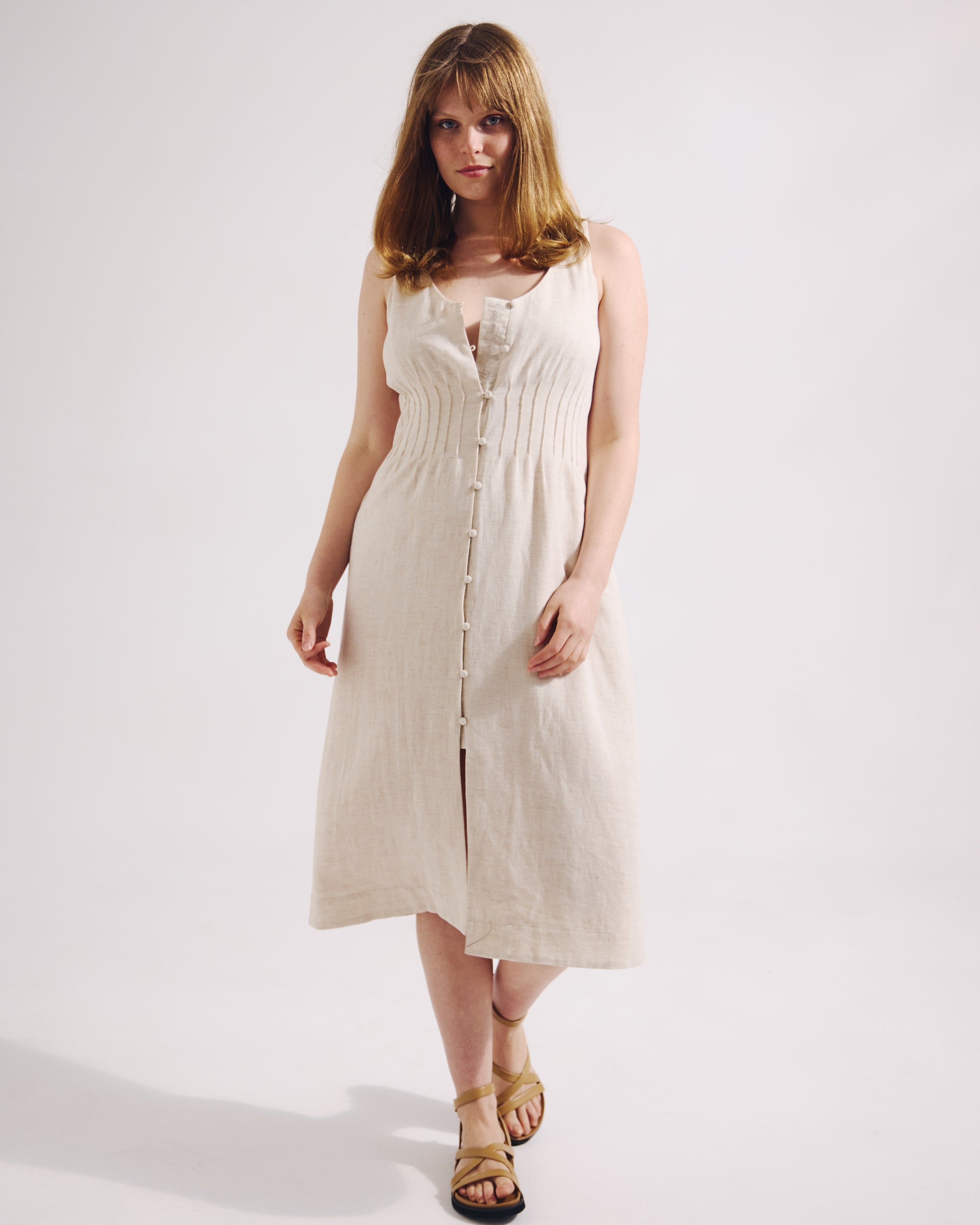 Woman wearing a white dress on a plain background