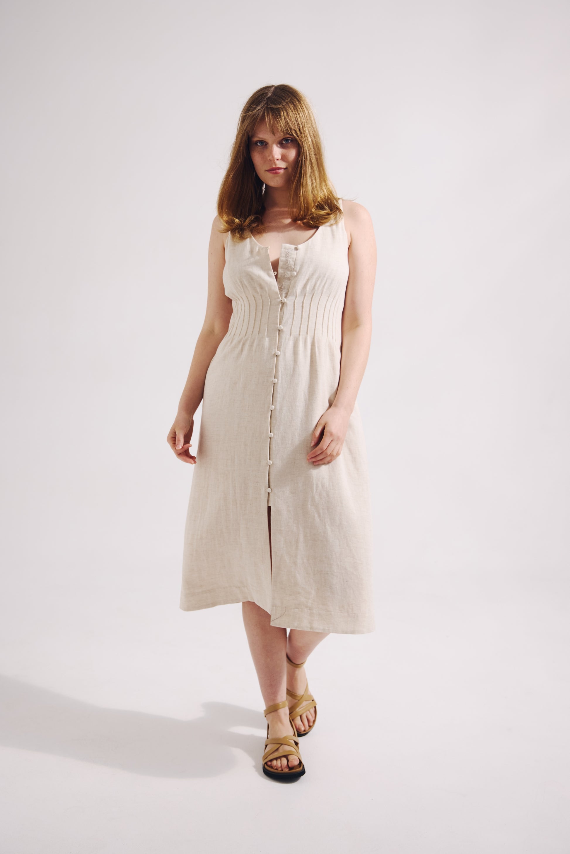 Woman wearing a white dress on a plain background