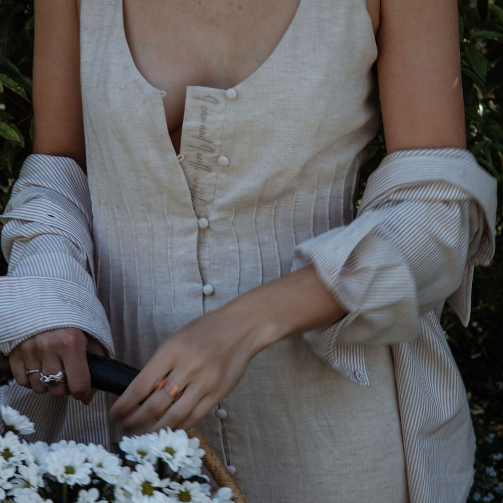 Person holding a basket of white flowers with a blurred natural background