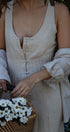 Person holding a basket of white flowers with a blurred natural background