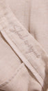 Close-up of beige fabric with 'Sheep Whisperer' embroidery