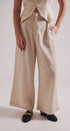 Person wearing beige wide-leg pants on a plain background