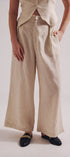 Person wearing beige wide-leg pants on a plain background