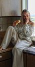 Woman sitting on a kitchen counter eating a croissant