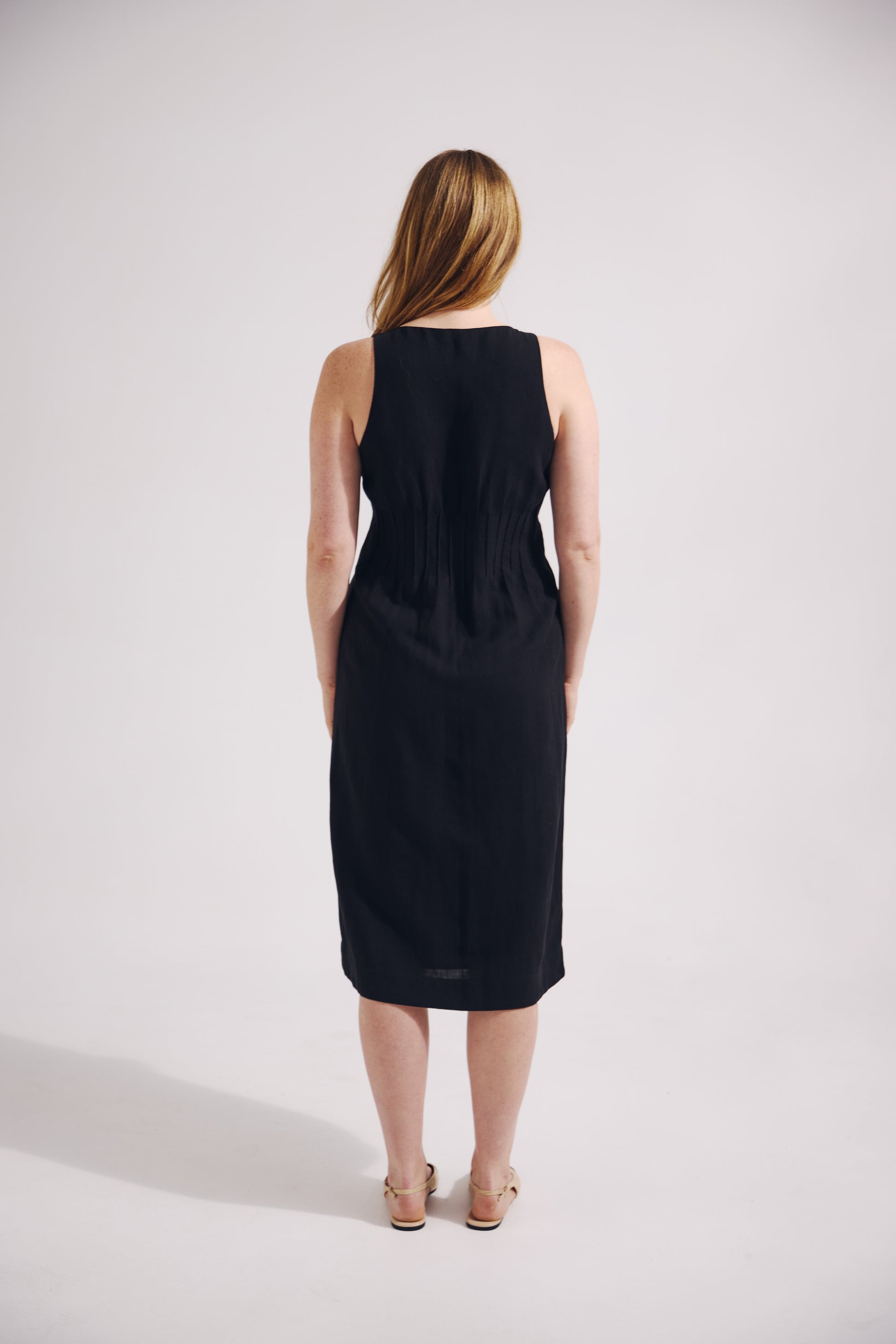 Woman wearing a black sleeveless dress on a white background