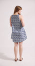 Woman wearing a sleeveless patterned dress on a white background