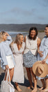Four women on a beach with a scenic background