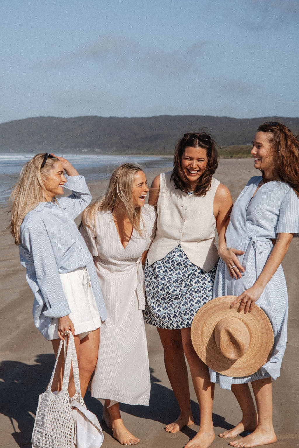 Four women on a beach with a scenic background
