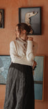 Woman standing in front of a wall with framed artwork