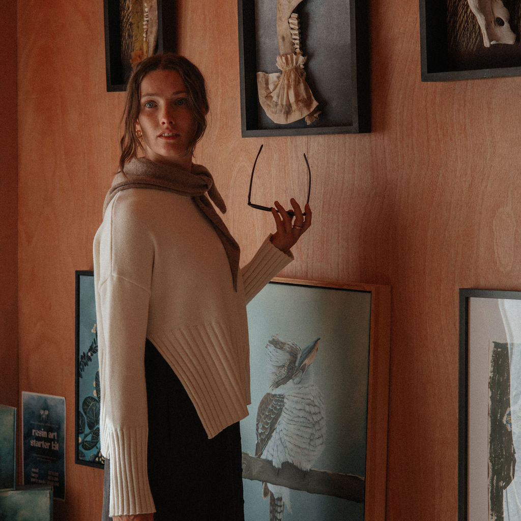 Woman standing in a room with framed animal skeletons on the wall