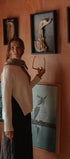 Woman standing in a room with framed animal skeletons on the wall