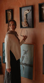 Woman standing in a room with framed animal skeletons on the wall