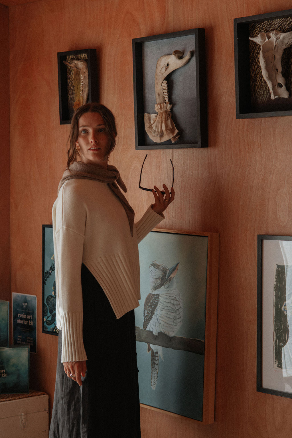 Woman standing in a room with framed animal skeletons on the wall