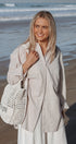 Woman holding a woven bag on a beach