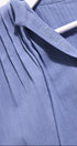Close-up of a blue garment with a brand label on a white background