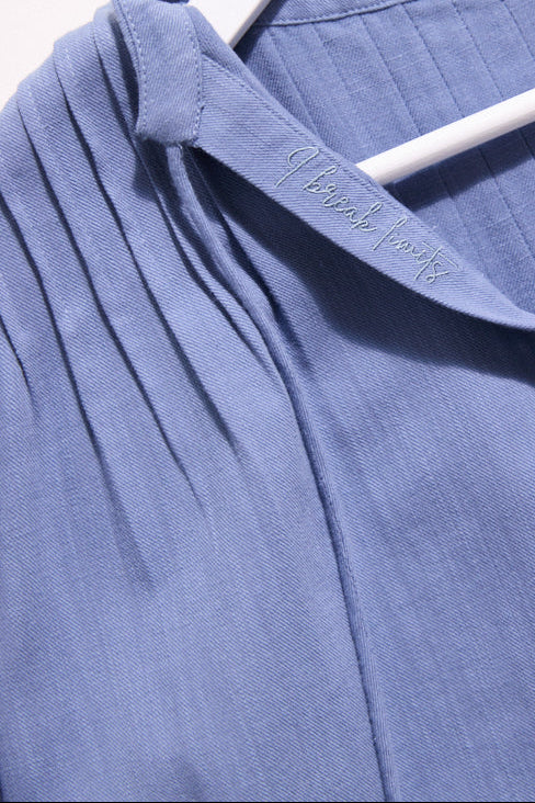 Close-up of a blue garment with a brand label on a white background