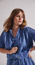 Woman wearing a blue dress against a plain background