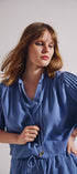 Woman wearing a blue dress against a plain background