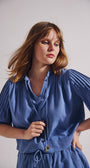 Woman wearing a blue dress against a plain background