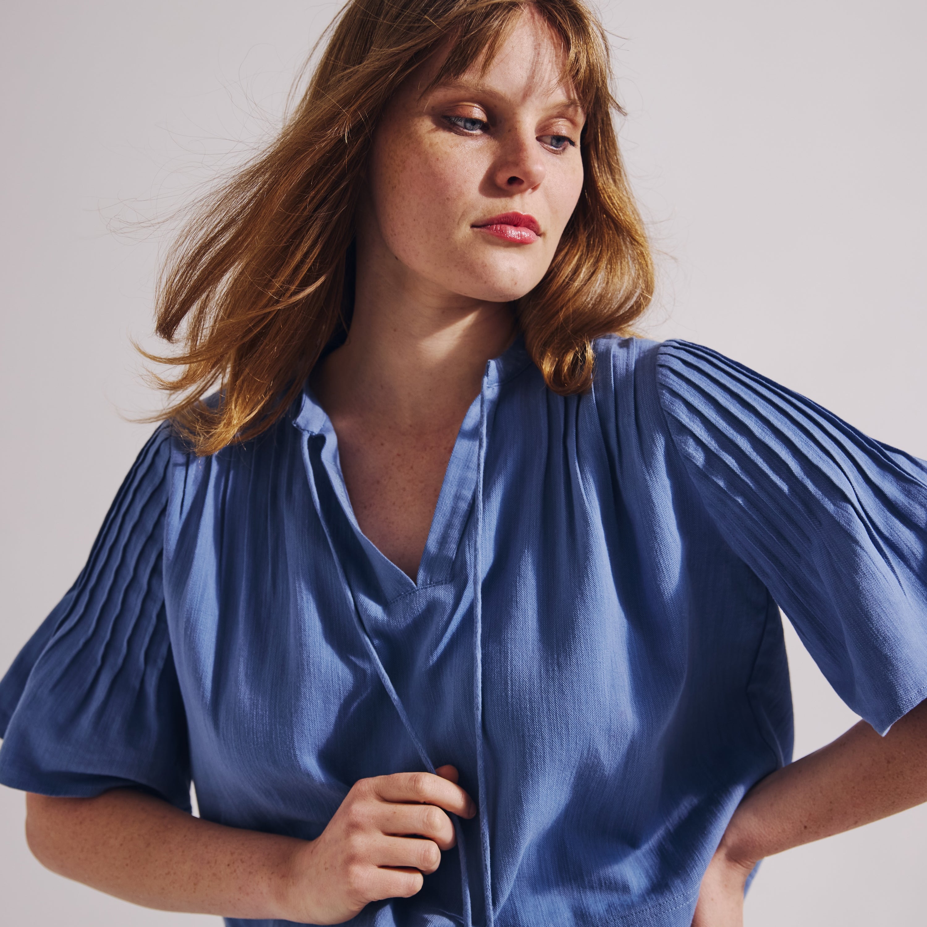 Woman wearing a blue dress against a plain background