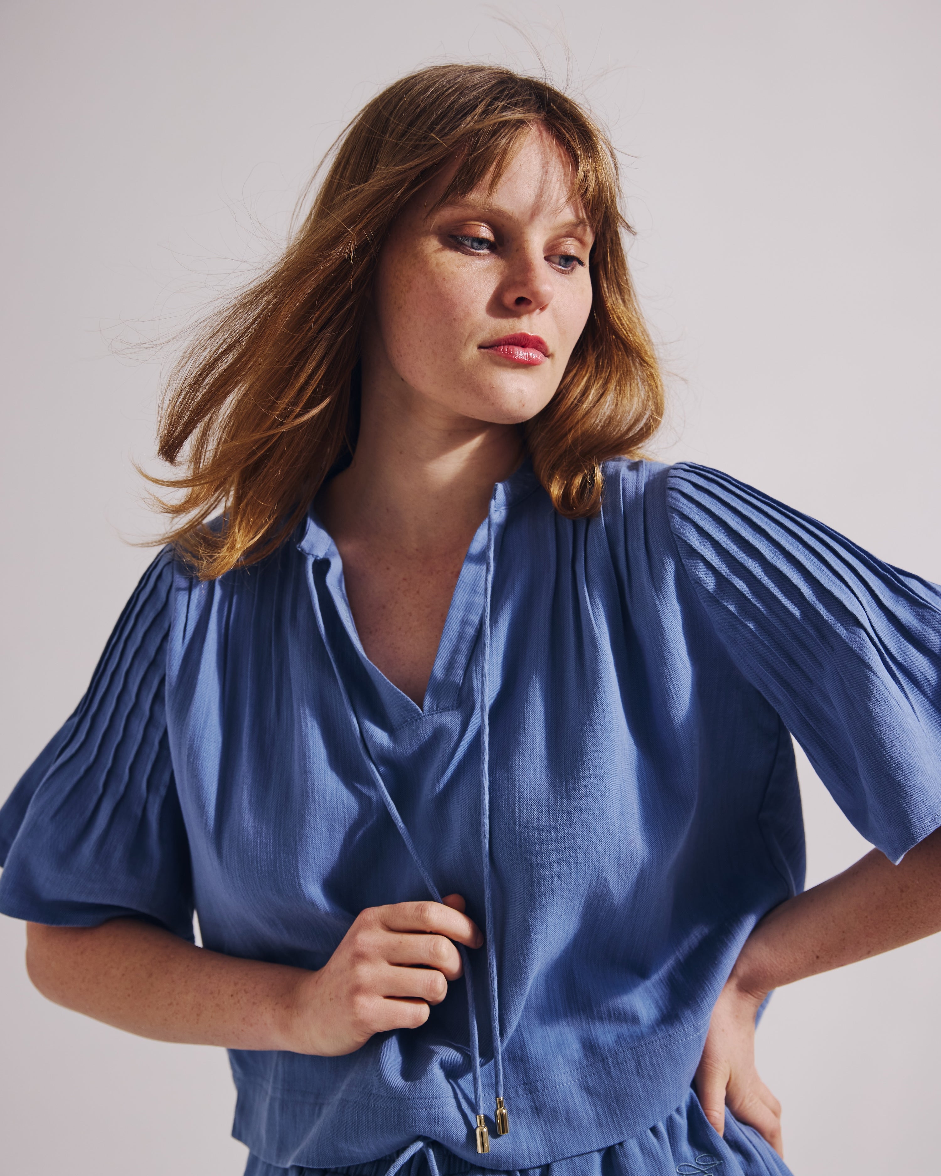 Woman wearing a blue dress against a plain background