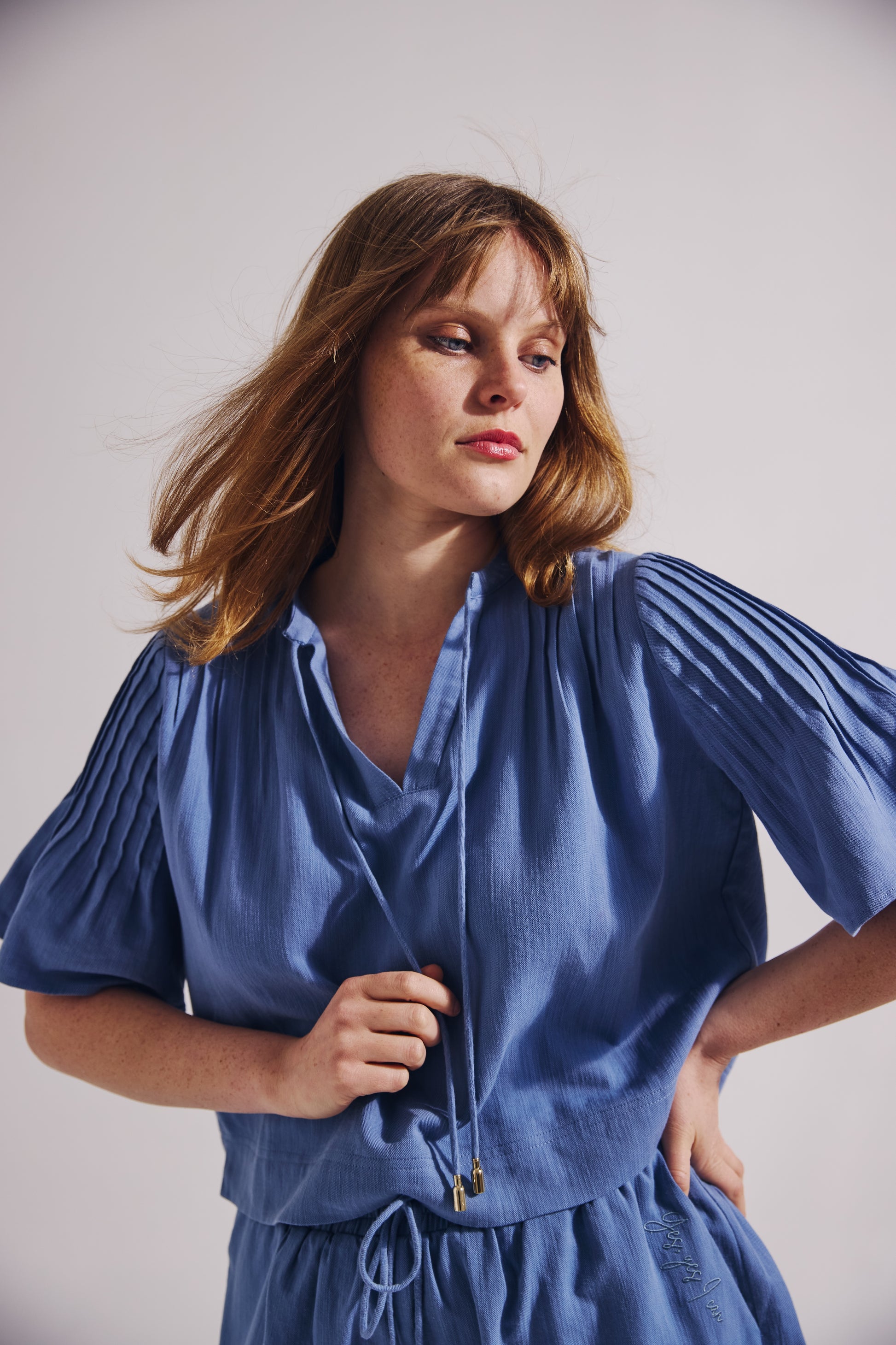 Woman wearing a blue dress against a plain background