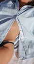Close-up of a person wearing a striped shirt with a blurred background