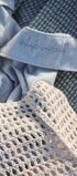 Textured fabric with a mesh bag and autumn leaves